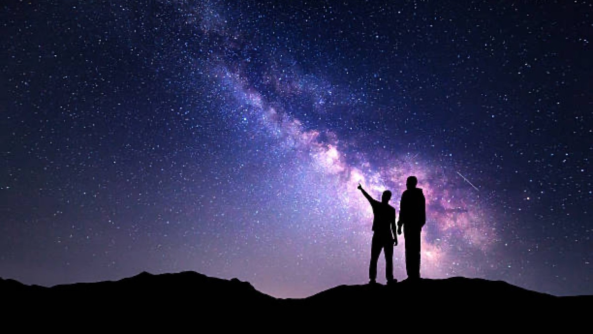 Padre e figlio osserva il cielo notturno e la galassia Via Lattea